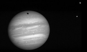 Jupiter och månarna Io (nedre) och Ganymede. Det är Ganymedes skugga som syns på Kupiter.