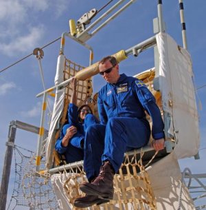 Fuglesang hoppar ur en av korgarna som ska ta bes�ttningen ner fr�n servicetornet vid en n�dsituation.