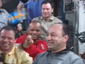 Fuglesang ombord p&aring; ISS med en svensk flagga.