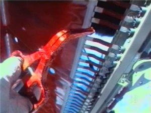 Forrester klipper en av de metallremsor som lossnat. Det syns tydligt hur v&auml;lisolerat t&aring;ngen &auml;r.