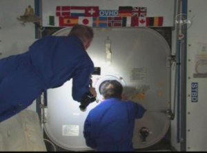 Mike Fincke och Koichi Wakata st�nger luckan till f�rbindelseg�ngen.