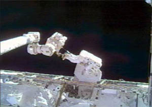 Mike Fossum f&aring;r hj&auml;lp av f&ouml;rflytta sig av stationens robotarm.