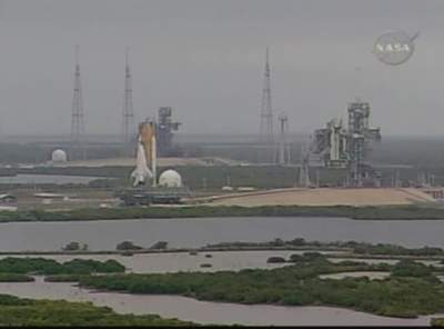 Atlantis på väg mot startplattan, i bakgrunden syns dem nya åskeldartornen omkring startplatta 39B.